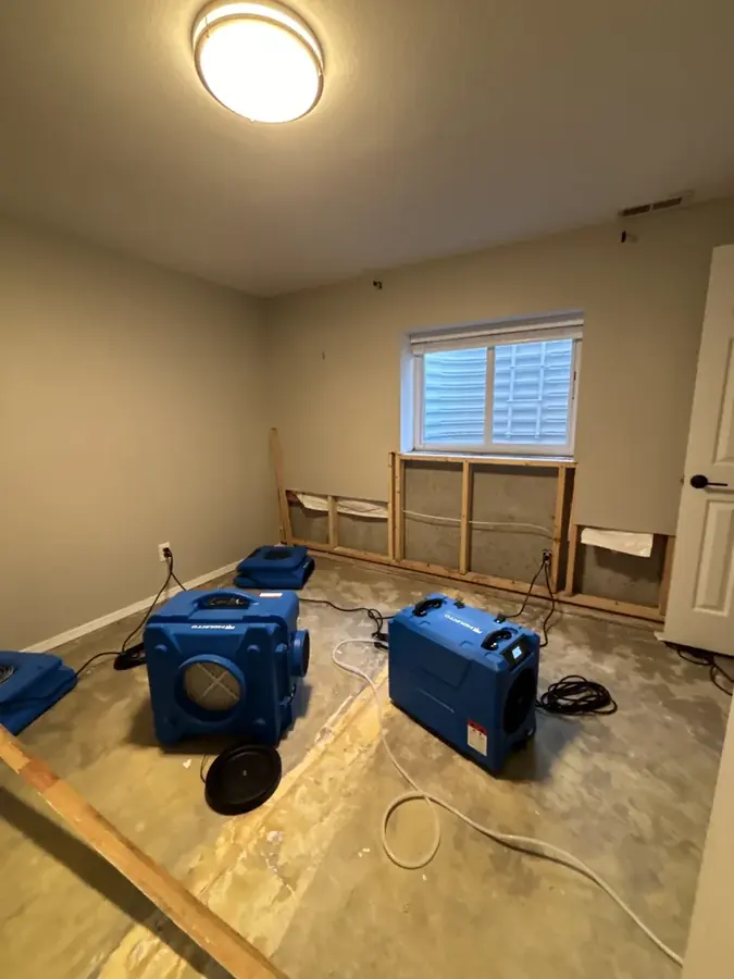 Blue air movers drying a flood-cut Milwaukee bedroom